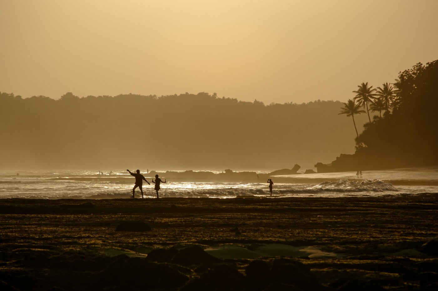 surfer walking in the sunset at NIHI Sumba, Indonesia