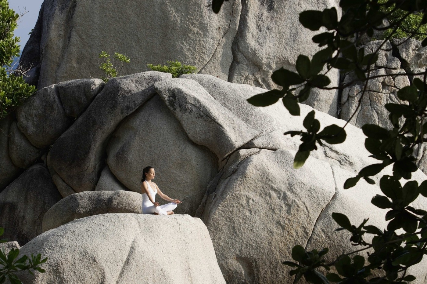 person doing yoga on the rocks at Nikoi Island, Indonesia