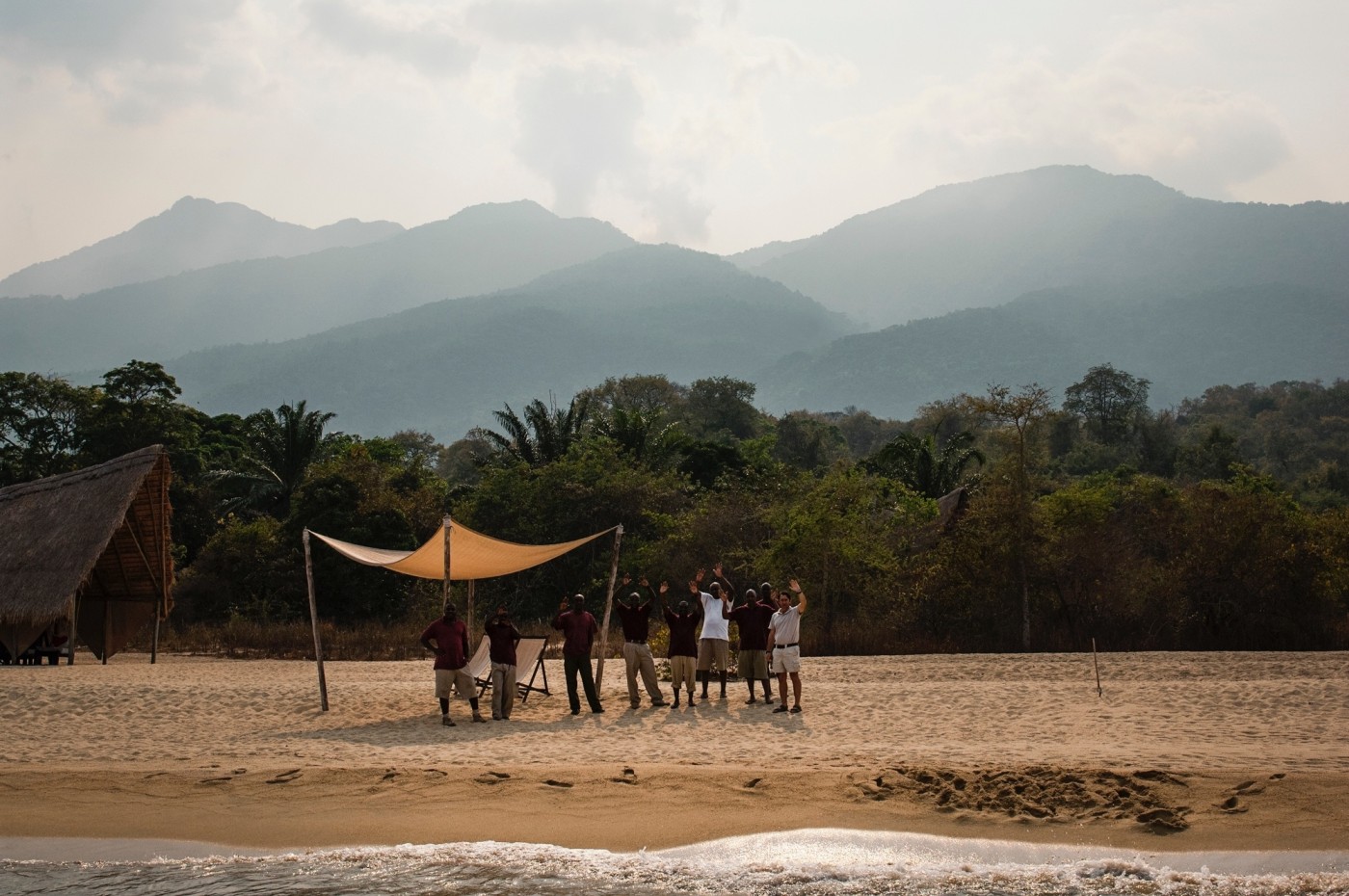 people waiving at the shore of the lake at Greystoke Mahale, Tanzania