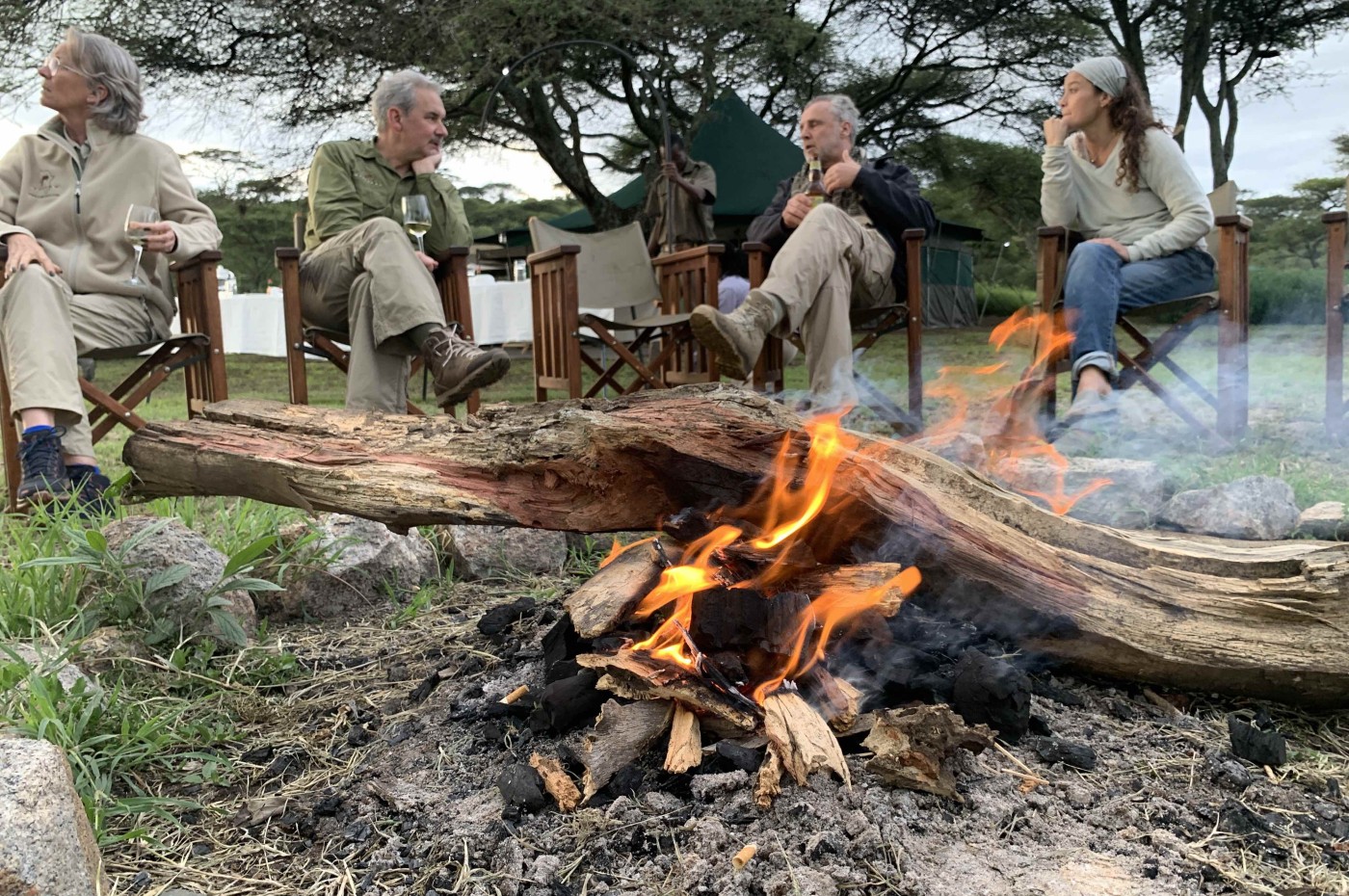 Bonfire and people relaxing at Wayo Serengeti Green Camp, Tanzania