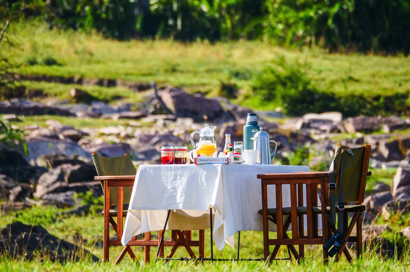 table with white cloth and chairs - ready with lunch at Wayo Serengeti Green Camp, Tanzania