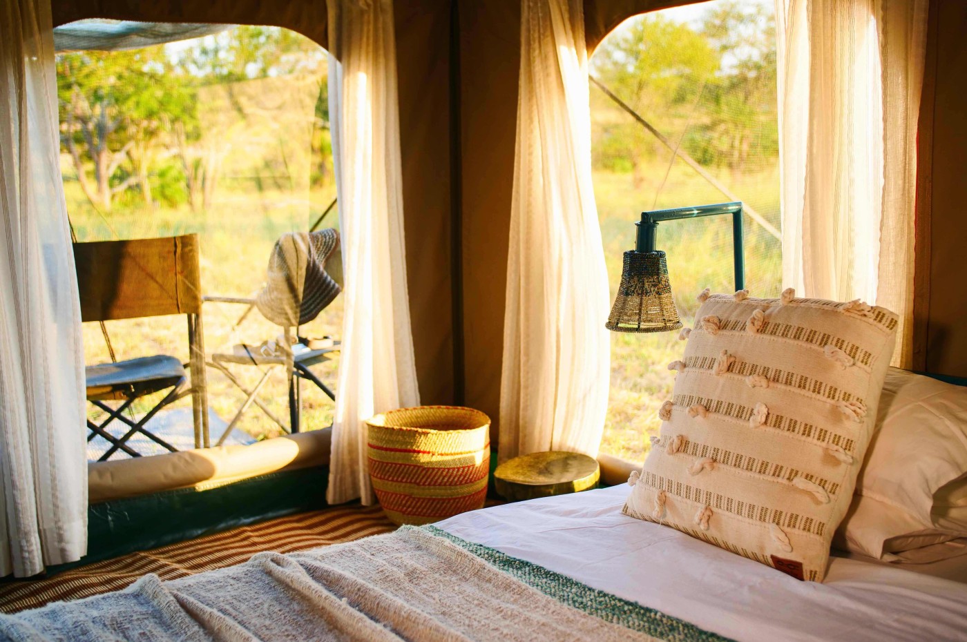 bed and chairs inside the tent at Wayo Serengeti Green Camp, Tanzania