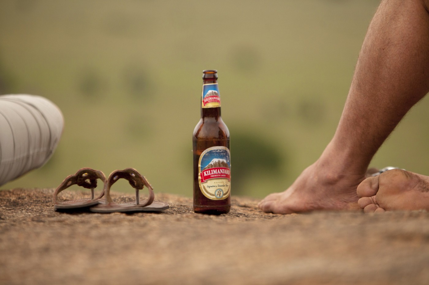 close up of beer, shoes and a foot at Wayo Walking Safari Camp, Serengeti, Tanzania