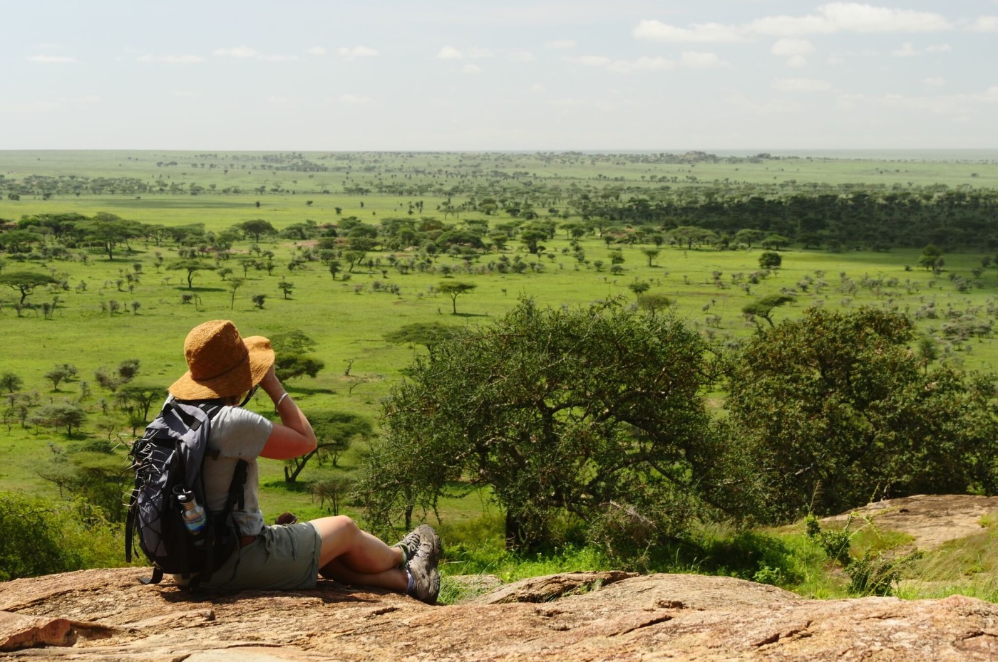 Person looking over the savannah with binoculars, Wayo Walking Safari Camp, Serengeti, Tanzania