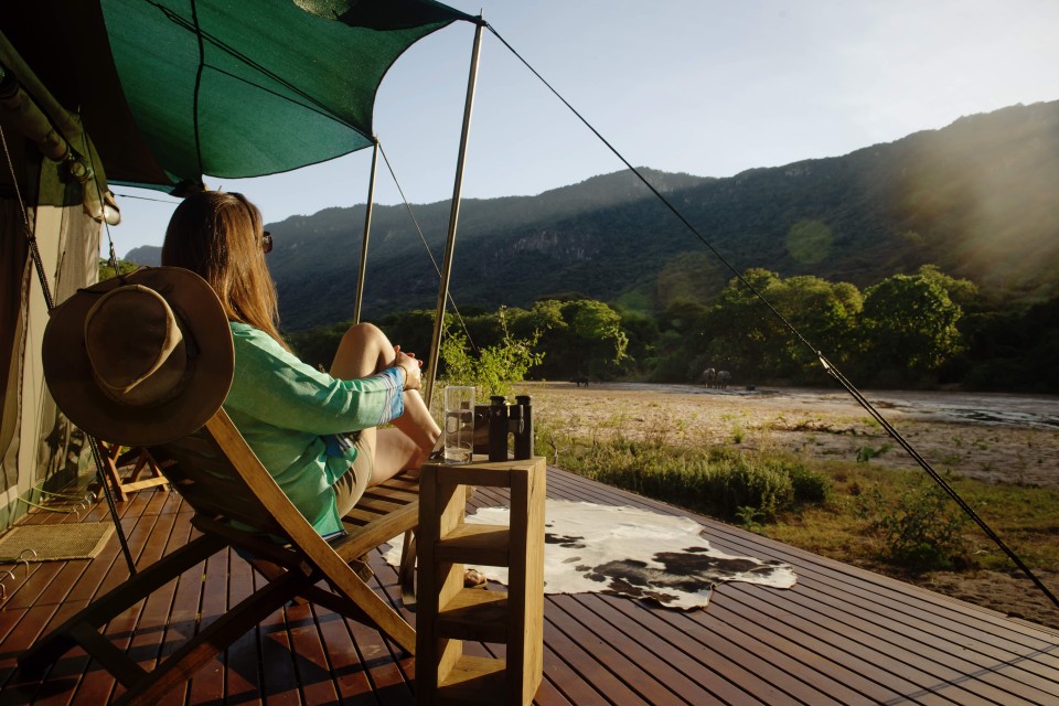 woman looking over the bush from her tent at Wayo Manyara Green Camp, Tanzania